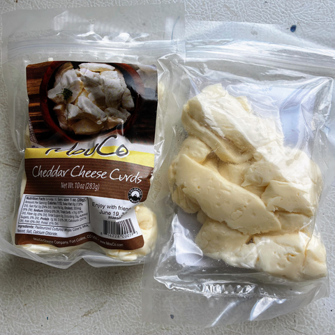 Package of Cheddar Cheese Curds with visible cheese curds outside the package on a white surface.