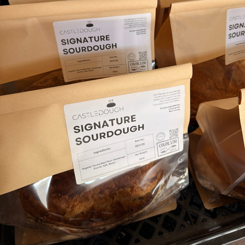 Packages of Castle Dough Signature Sourdough with visible branding and product details.